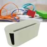 Large green/white cable management box with ventilation holes, hiding power cords under desk. Neat and organized workspace.