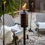 Copper/Bronze TIKI Brand 65-inch adjustable metal deck torch, usable as a full-height, tabletop, or garden torch.